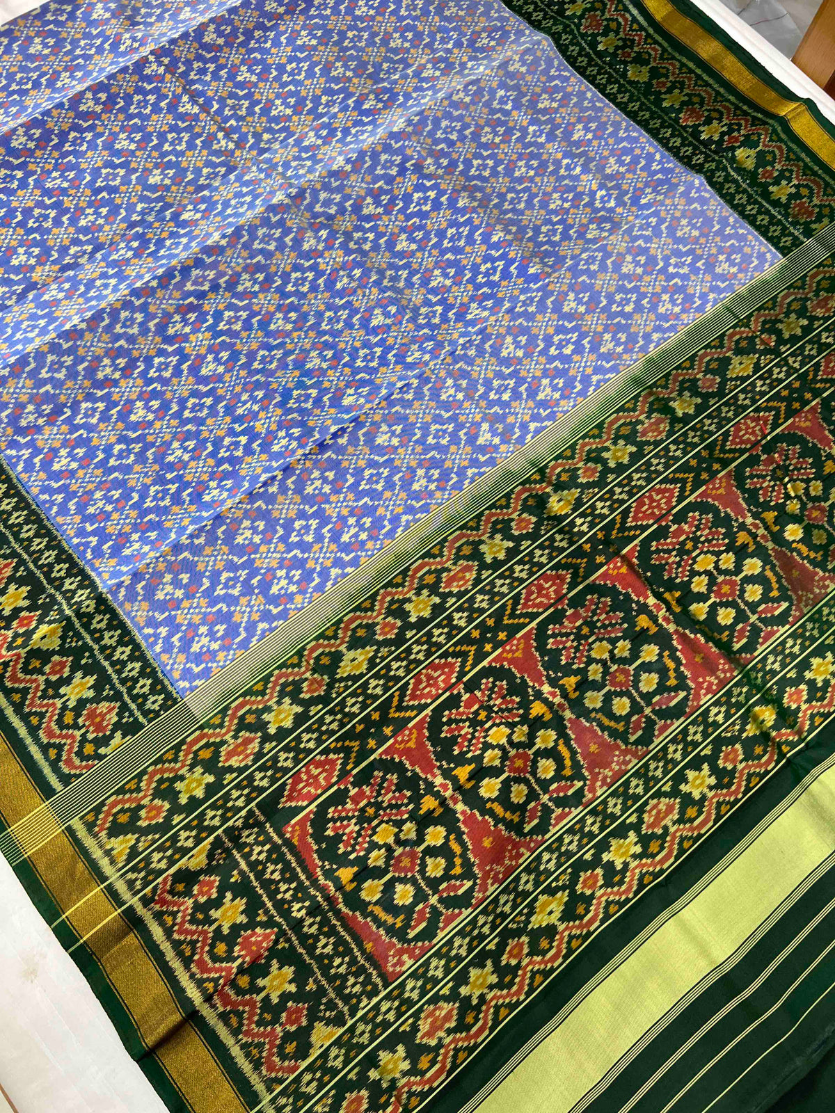 Beautiful sky blue batton-full desing with green bordar Pallu Patola sarees