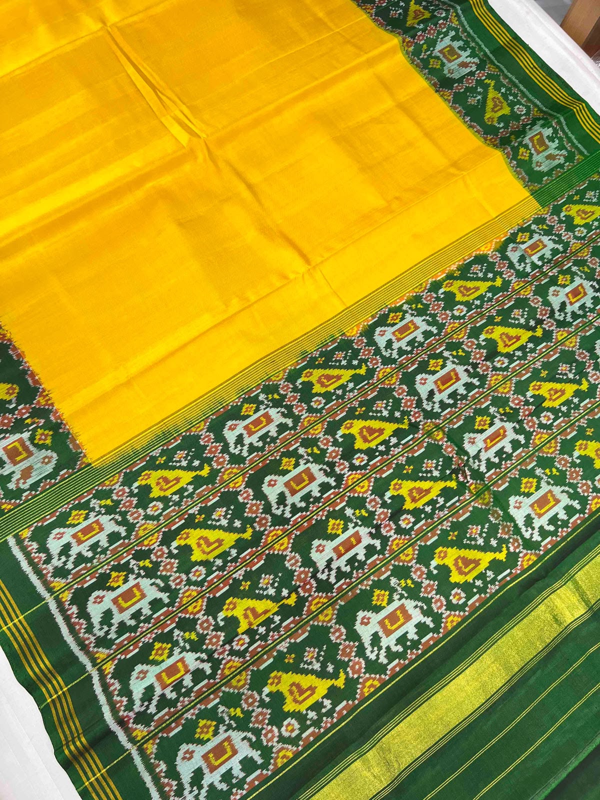 Beautiful plain yellow gala design with green bordar Pallu premium patola silk saree