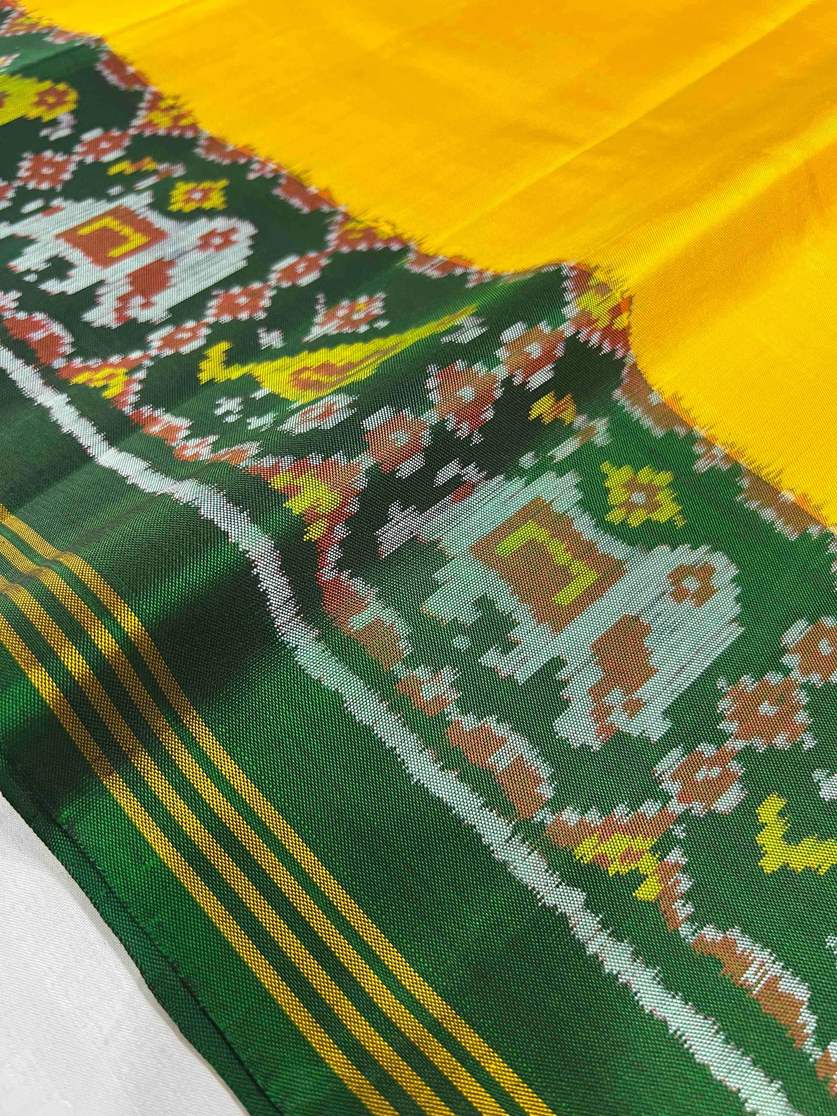 Beautiful plain yellow gala design with green bordar Pallu premium patola silk saree